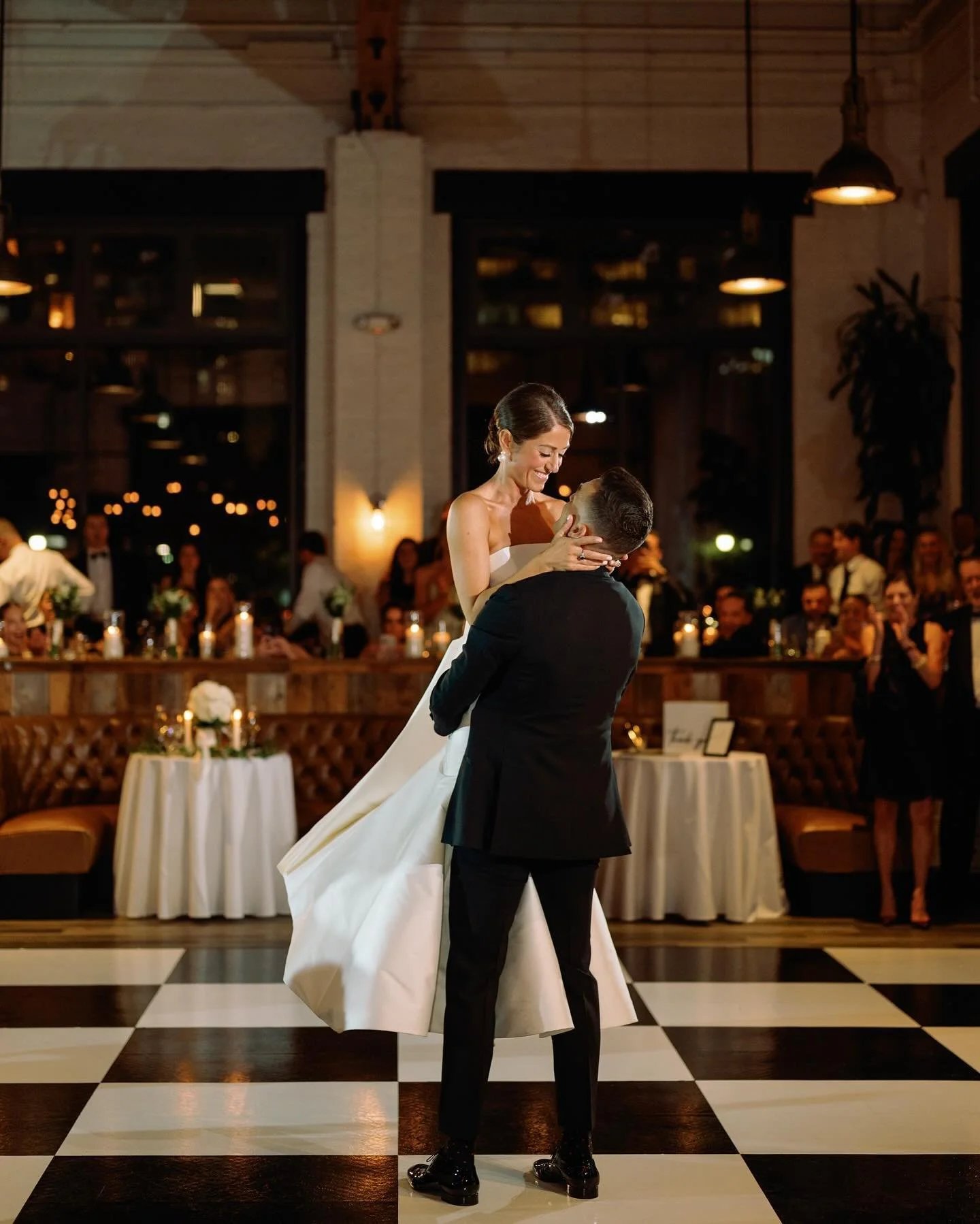 Couple sharing their first dance on a dance floor at an elegant indoor wedding reception in Salt Lake City